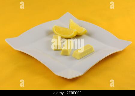 Zitrone weiße Schokolade Wafer Snacks mit Zitronen auf weißem Dessert Platte auf gelbem Hintergrund Stockfoto