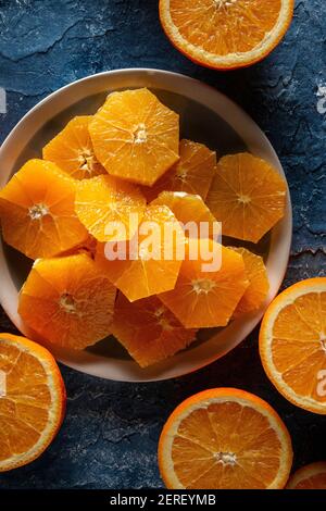 Flache Lage von plattierten orangefarbenen Scheiben auf blauem Hintergrund Stockfoto