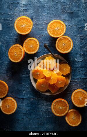 Flache Lage von plattierten orangefarbenen Scheiben auf blauem Hintergrund Stockfoto
