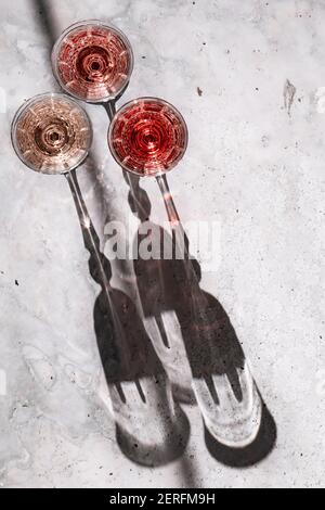Drei Roséweine´ Gläsern, die harte Schatten werfen. Stockfoto