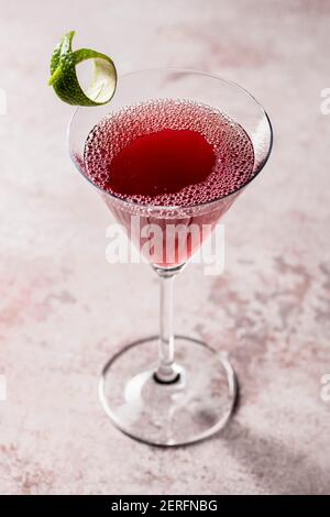 Kosmopolitischer Granatapfel-Cocktail in einem martini-Glas mit Limettenverdrehung. Stockfoto