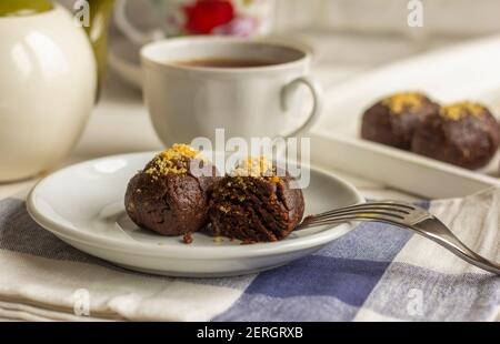 Heißer Tee in einer weißen Tasse und hausgemachter Schokoladenkuchen auf dem Tisch. Stockfoto