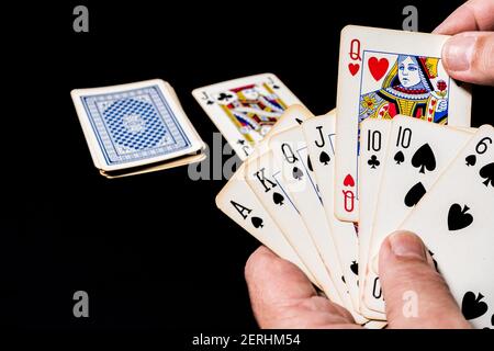 Poker-Kartenspiel auf einem Tisch. Hand hält einige Karten zeigt sein Spiel. Wählen Sie eine Karte zum Abwerfen aus.