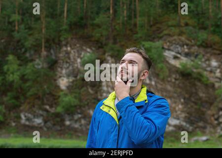 Porträt eines hübschen jungen bärtigen Mannes, der nachdenklich in den Himmel schaut. Lösung des Problems. Auf der Suche nach Inspiration. Kreative Persönlichkeit. Stockfoto