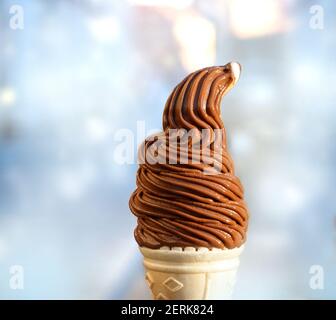 Leckeres Schokoladeneis in einem Waffelhorn auf einem Blurender Hintergrund Stockfoto