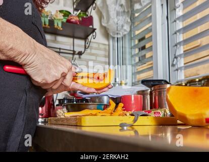 Kochen zu Hause in der Küche nach Rezept aus dem Internet. Frau reinigt den Dolorit für die Herstellung von Risotto. Schritt für Schritt Rezept Stockfoto