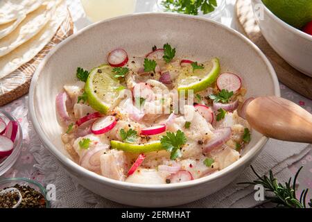 Nahaufnahme einer peruanischen Ceviche mit Fischstücken und Zitronen Stockfoto