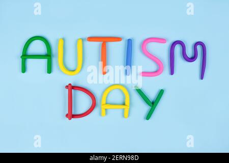 World Autism Awareness Day Konzept - mehrfarbige Buchstaben aus Play-Doh oder anderen sensorischen Spielschaum auf blauem Hintergrund. Autismus-Spektrum-Störung und Stockfoto