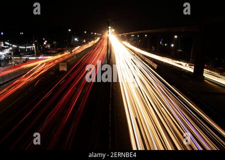 Geschwindigkeit Ampelspuren auf der Autobahn, Langzeitbelichtung, städtischer Hintergrund und dunkler Himmel Stockfoto