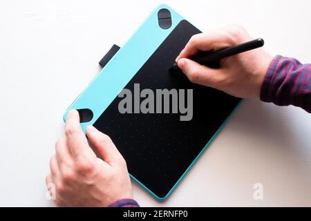 illustrator Designer zeichnet auf Grafiktablett auf weißem Hintergrund Stockfoto
