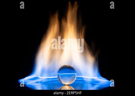 Glaskugel mit Feuerflammen auf schwarzem Hintergrund. Speicherplatz kopieren. Stockfoto