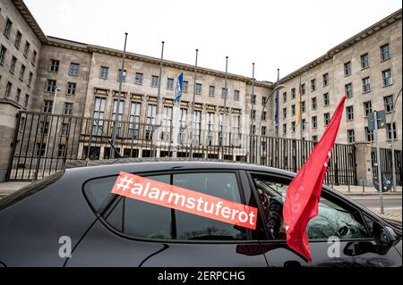 Berlin, Deutschland. Februar 2021, 28th. Ein Auto mit dem Aufkleber „Alarmstufe Rot“ fährt bei der Automonstration der Eventbranche am Bundesministerium der Finanzen vorbei. Quelle: Fabian Sommer/dpa/Alamy Live News Stockfoto