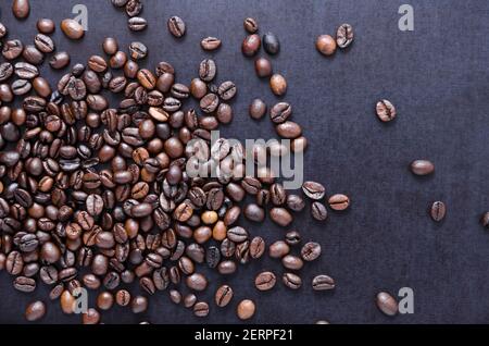 Lose geröstete Espresso Kaffeebohnen auf dunklem Hintergrund, Nahaufnahme, flache Lay-Ansicht von oben, Stillleben, ich liebe Kaffee-Konzept Stockfoto