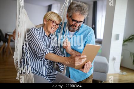 Glücklich lächelnd reifes Paar mit digitalen Tablet zu Hause Stockfoto