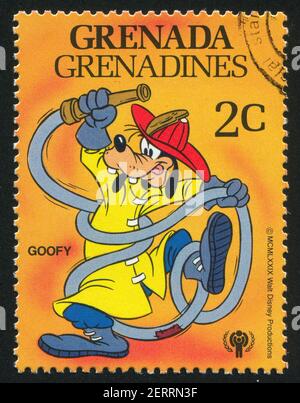 GRENADA - UM 1979: Briefmarke gedruckt von Grenada, zeigt Walt Disney Figuren, Fireman Goofy, um 1979 Stockfoto