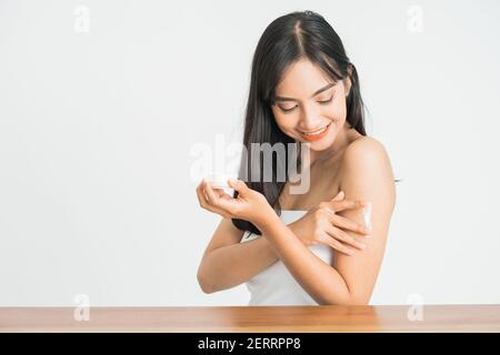 Junge Hautpflege asiatische Frau Anwendung Körperlotion auf Arm Und Schulter Stockfoto