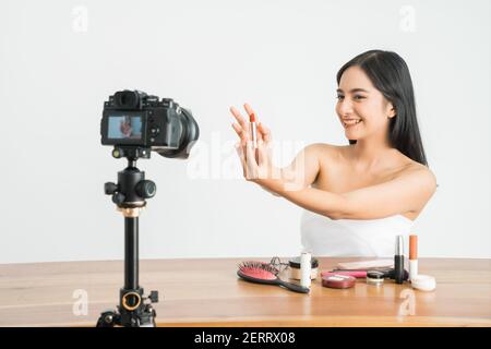 Junge schöne asiatische Frau professionelle Schönheit vlogger oder Blogger Aufnahme Erstellen Sie ein Tutorial, um es in sozialen Medien über Weiß zu teilen Hintergrund Stockfoto