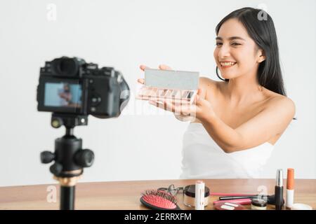 Junge schöne asiatische Frau professionelle Schönheit vlogger oder Blogger Aufnahme Erstellen Sie ein Tutorial, um es in sozialen Medien über Weiß zu teilen Hintergrund Stockfoto