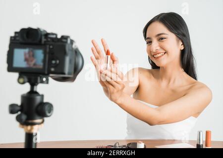 Junge schöne asiatische Frau professionelle Schönheit vlogger oder Blogger Aufnahme Erstellen Sie ein Tutorial, um es in sozialen Medien über Weiß zu teilen Hintergrund Stockfoto