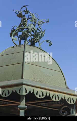 VAUX, FRANKREICH, 24. Februar 2021 : Trauben als architektonisches Detail der Pissotiere, ein Denkmal des Dorfes Clochemerle. Stockfoto