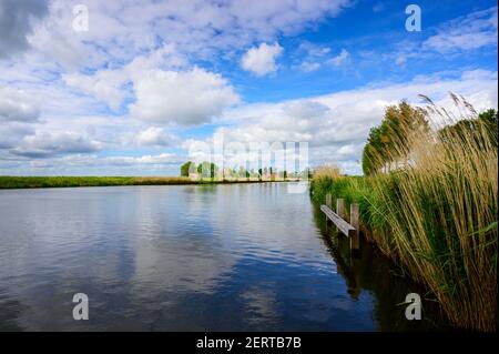 Fluss in holländischer Landschaft mit Wolkenspiegelung, Nordholland, Niederlande. Stockfoto