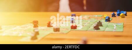 Russland, Dezember 2020: Zwei Männer Freunde haben Spaß am carcassonne Brettspiel spät am Abend oder in der Nacht. Männliche Hände und Spielkarten und Chip Stockfoto