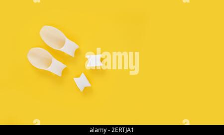 Weißer Silikon-Fingerteiler auf gelbem Hintergrund. Prävention und Behandlung von Hallux Valgus Stockfoto