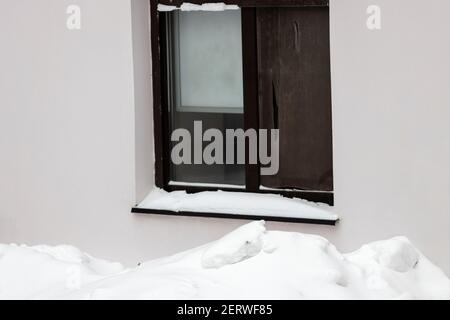 Schneehaufen am Fenster eines Mehrfamilienhauses. Hochwertige Fotos Stockfoto