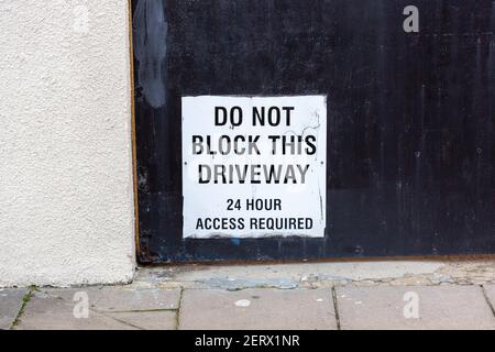 Ein Schild auf einer Garage mit der Aufschrift, diese Auffahrt nicht zu blockieren, in ständiger Nutzung Stockfoto