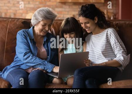 Glückliche drei Generationen von Frauen entspannen mit Laptop Stockfoto