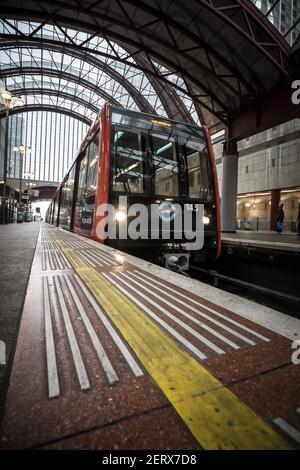 Ein Bombardier B2007 Docklands Light Railway Zug wartet auf dem Bahnsteig im DLR-Bahnhof Canary Wharf, London, England Stockfoto