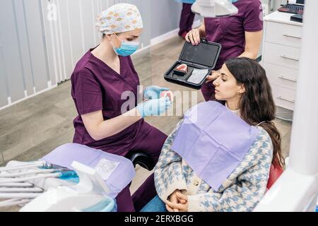 Stock Foto von Frau im Zahnarztstuhl sitzen auf Zahndeckeln setzen. Stockfoto