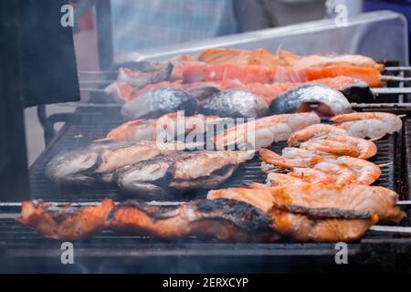 Kochen Lachs, Tiger Garnelen, Garnelen Spieße und Makrelen Fisch auf dem Grill Stockfoto