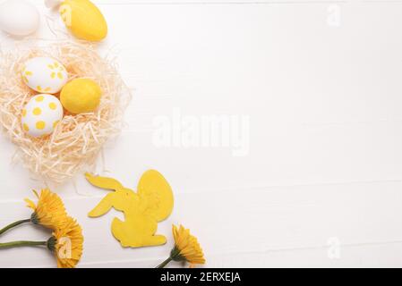 Ostereier, Blumen, gelbes Kaninchen. Festlicher Frühlingshintergrund. Flach liegend, Draufsicht, Kopierbereich Stockfoto