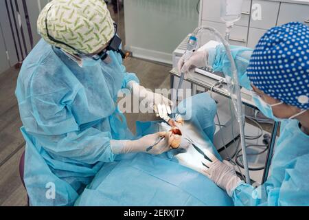 Stock Foto von Frauen Team trägt Gesichtsmasken und Haarnetze arbeiten in der Zahnklinik. Stockfoto