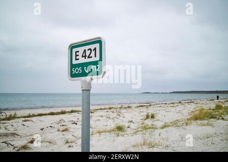 Ein grünes Hilferschild am Strand Stockfoto