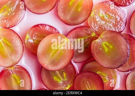 Hälften roter Trauben auf weißem Hintergrund, Muster. Bio-Kosmetik mit pflanzlichen Inhaltsstoffen. Stockfoto