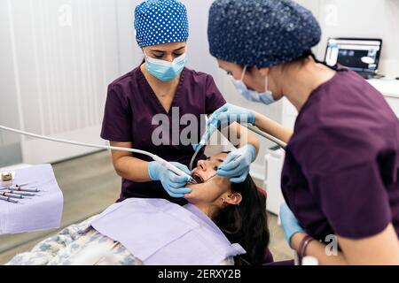 Stock Foto von weiblichen Zahnärzten tragen schützende Gesichtsmaske Untersuchung eines Patienten. Stockfoto