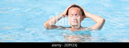 Porträt einer Frau mit geschlossenen Augen im Wasserpark im Pool. Stockfoto