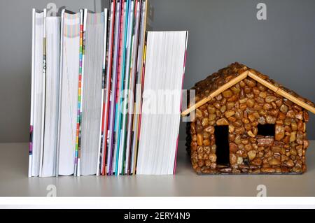 Bücher, Stapel neuer Bücher auf Holztisch mit Steinhaus als Stütze, Brasilien, Südamerika Stockfoto