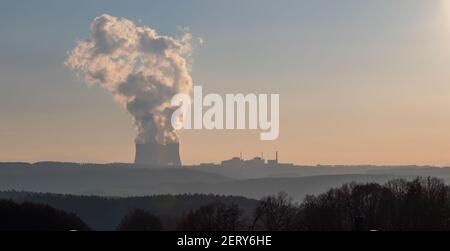 Temelin, Tschechische republik - 02 28 2021: Kernkraftwerk Temelin, dampfende Kühltürme in der Landschaft am Horizont bei Sonnenuntergang Stockfoto