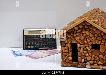 Stone House, Stone House mit finanziellen und wissenschaftlichen Rechner und Geldscheine aus Brasilien, Südamerika, mit selektivem Fokus auf den Hintergrund Stockfoto