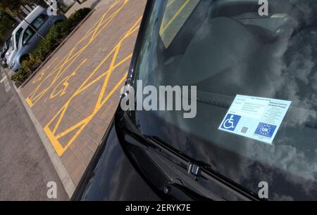 Eine Windschutzscheibe mit einem Behindertenausweis und Markierungen für Inhaber von Behindertenausweisen nur auf einem Parkplatz in Schottland, Großbritannien Stockfoto