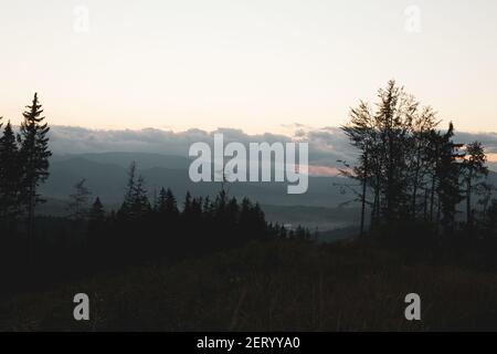 Eine wunderschöne Landschaft mit Bergen, die unter dem wolkigen Himmel glänzen Im Park Stockfoto