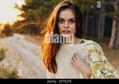 Rothaarige Frau, die auf ihren Schultern und in einem Pullover radeln Im Wald auf der Straße Stockfoto