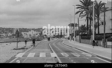 JAVEA, SPANIEN - 23. Feb 2021: Menschen, die auf beiden Seiten der Avenida del Mediterraneo in Quarantäne gehen, ohne dass Autos zirkulieren. Stockfoto