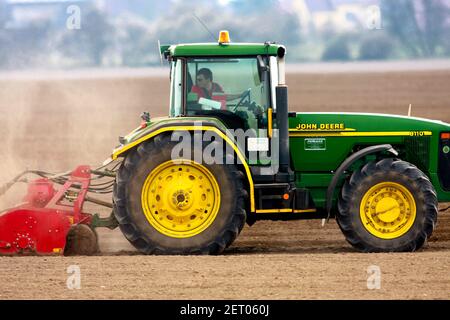 Ein Landwirt fahren Traktor John Deere und blickt zurück auf Prüfen Sie die geleistete Arbeit Stockfoto