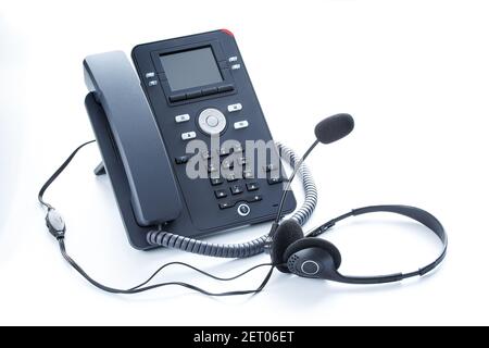IP-Telefon und Headset auf weißem Hintergrund eingetönt Grau-blaue Farbe Stockfoto