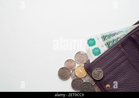 Russische Rubel in der Brieftasche auf weißem Hintergrund. Tausend Scheine und verschiedene Münzen.Platz für Text. Stockfoto