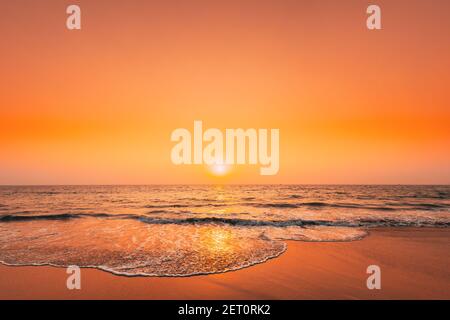 Sonnenuntergang Sonne Über Meer. Natürlicher Sonnenaufgang Himmel Warme Farben Über Dem Wellenmeer. Ocean Water Schaum Waschen Sandstrand Bei Sonnenuntergang Stockfoto